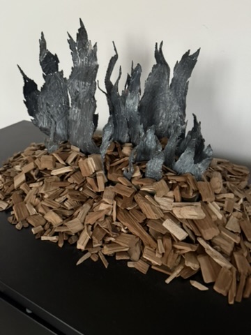 Kevin Boehm’s sculpture: jagged dark forms rising from a bed of wood chips